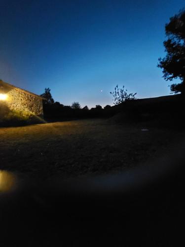 a view of a field at night with a building at Molino della Tuoma in San Quirico dʼOrcia