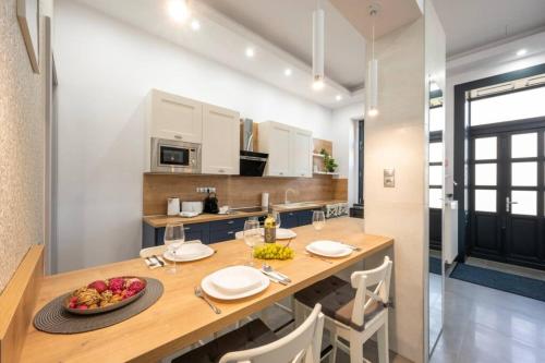 a kitchen with a table with a bowl of fruit on it at Luxus a város felett in Szombathely