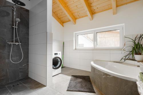 a bathroom with a tub and a washing machine at Ferienwohnung Schreierhof Bio Bauernhof in Feldkirchen in Kärnten