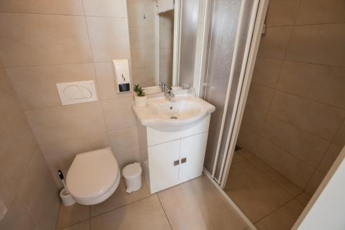 a small bathroom with a toilet and a sink at Rooms Klik Postojna in Postojna