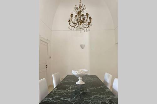jadalnia ze stołem i żyrandolem w obiekcie Villa Luciana w mieście Martina Franca