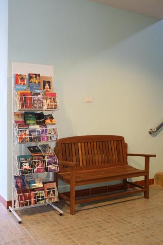 a wooden bench sitting in a room with magazines at BT Mansion in Lamai