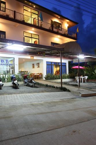 two motorcycles parked in front of a building at night at BT Mansion in Lamai