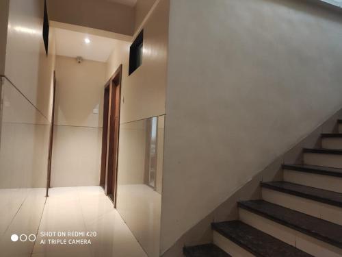 a staircase in a house with a window and a door at Sai Sunder Guestline in Navi Mumbai