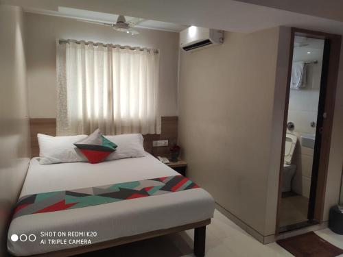 a small bedroom with a bed and a mirror at Sai Sunder Guestline in Navi Mumbai