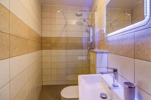 y baño con lavabo, aseo y espejo. en Villa ELEA, en Novi Vinodolski