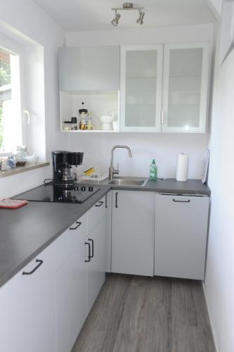 a white kitchen with white cabinets and a sink at Claar Ferienwohnung Lindau Bodensee in Lindau