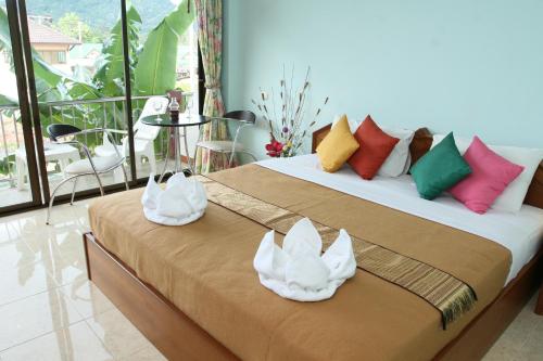 um quarto com uma cama com duas toalhas brancas em BT Mansion em Lamai