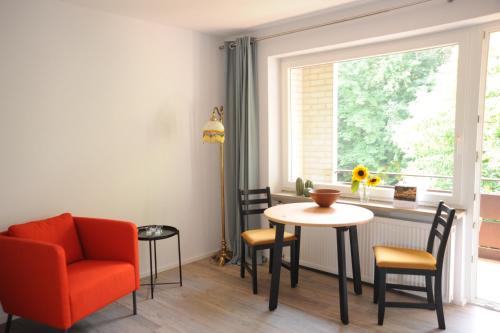 a living room with a table and a chair and a window at Claar Ferienwohnung Lindau Bodensee in Lindau