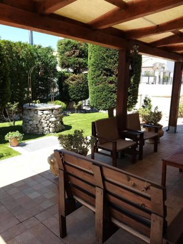 a patio with two wooden benches and a stone fountain at Affittacamere La Madonnina in San Giovanni Rotondo