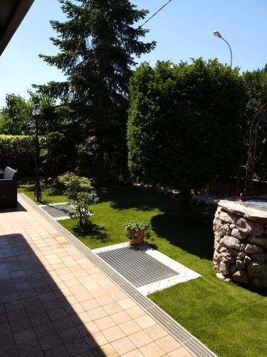 a garden with a tree and a stone wall at Affittacamere La Madonnina in San Giovanni Rotondo