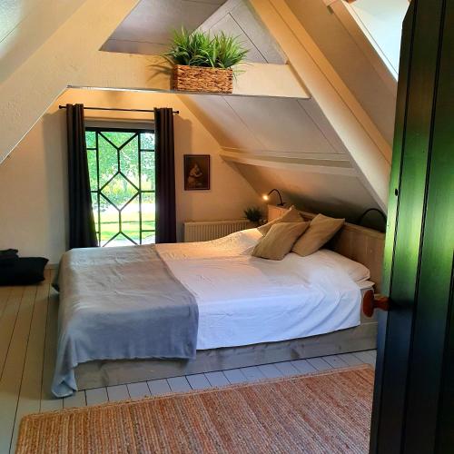 a bedroom with a white bed with a plant on the ceiling at Op Stolk bed & breakfast in Stolwijk