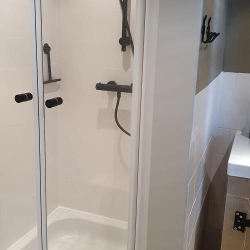 a shower with a glass door in a bathroom at Op Stolk bed & breakfast in Stolwijk
