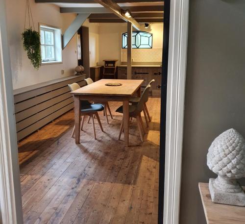 a dining room with a wooden table and chairs at Op Stolk bed & breakfast in Stolwijk