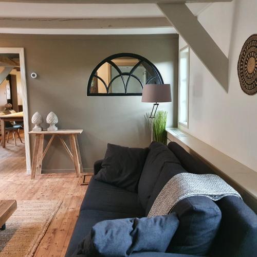 a living room with a couch and a window at Op Stolk bed & breakfast in Stolwijk