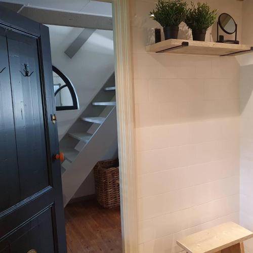 a hallway with stairs and a black door at Op Stolk bed & breakfast in Stolwijk