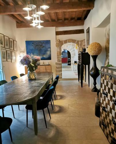 a dining room with a wooden table and chairs at Palais Aoma, hôtel particulier de luxe en Provence in LʼIsle-sur-la-Sorgue