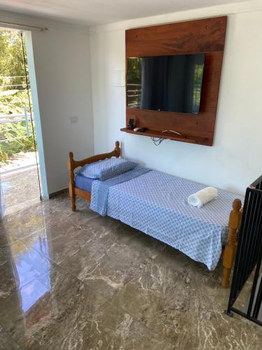 1 Schlafzimmer mit 2 Betten und einem Flachbild-TV in der Unterkunft Casa Charmosa in Paraty