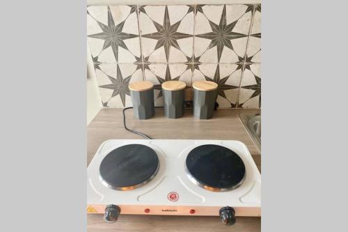 a stove with two cups on top of it at Self contained annexe in the heart of Wedmore in Wedmore