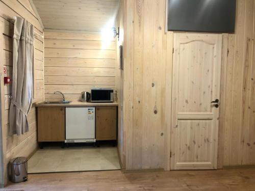 a kitchen with a counter and a door and a sink at Krodziņš Kristapiņš in Babīte