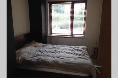 a bed in a room with a window and a bed sidx sidx at Charming flat in Golders Green with parking space in London