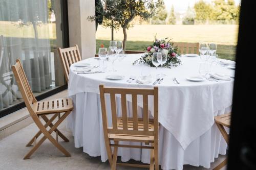 a white table with glasses and a flower arrangement on it at Conimbriga Hotel do Paço in Condeixa a Nova