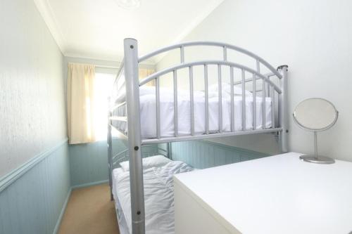 a bedroom with a bunk bed with a mirror at 43C Medmerry Park 2 Bedroom Chalet in Earnley