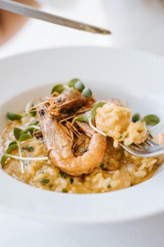 a white bowl of food with shrimp and rice at Conimbriga Hotel do Paço in Condeixa a Nova