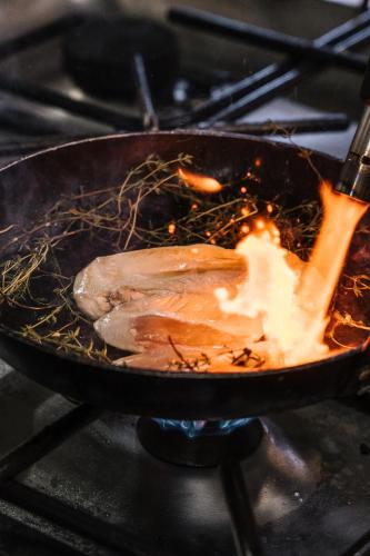 a chicken being cooked in a pan on a stove at Conimbriga Hotel do Paço in Condeixa a Nova