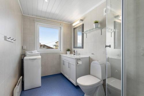 a bathroom with a toilet and a sink and a window at Apartment with amazing views - free parking in Arendal