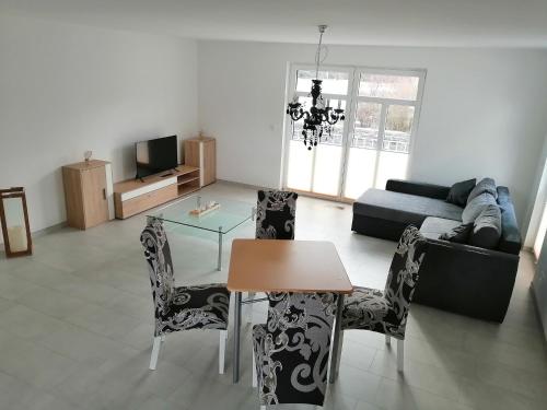 a living room with a table and chairs and a couch at Ferienwohnung am Schloßpark in Bad Berleburg