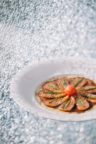 a plate of food with a shrimp on a table at Nobu Hotel Warsaw in Warsaw