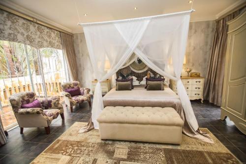 1 dormitorio con 1 cama con dosel en Godiva Spa & Guesthouse en Groblersdal