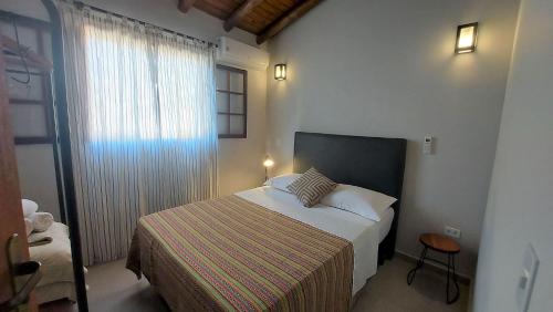 ein kleines Schlafzimmer mit einem Bett und einem Fenster in der Unterkunft Ventura - Apto com piscina, vista mar, churrasqueira privativa, ar con, wi-fi, netflix, garagem in Paraty