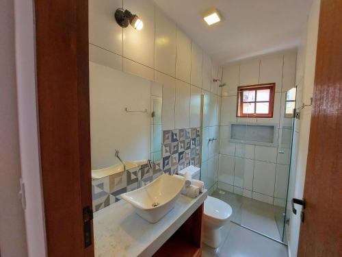 un baño con lavabo e inodoro en Cedro - Flat recém inaugurado, 50mts da Praia, Churr, Piscina, WiFi eficiente, Netflix, en Paraty
