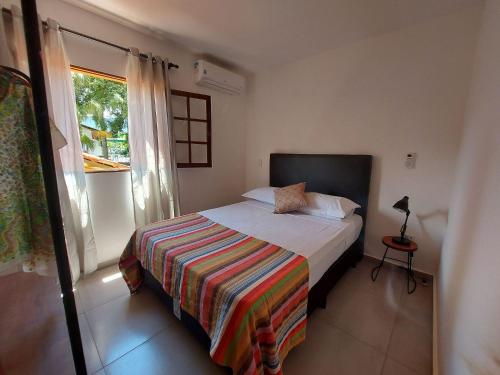ein kleines Schlafzimmer mit einem Bett und einem Fenster in der Unterkunft Cotia - Novo Flat com Piscina, 50mts da praia, churrasqueira privativa, ar con, wi-fi, netflix, garagem in Paraty