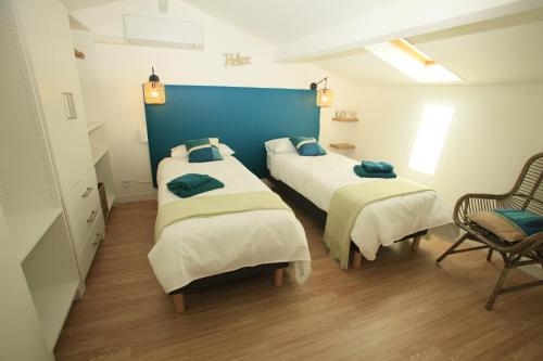 a room with three beds and a blue wall at Villa Mama Cocha 8 minutes à pied des plages in Sanary-sur-Mer