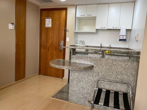 a kitchen with a counter and a chair in it at Flat, Savassi Condomínio Century in Belo Horizonte