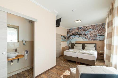 a bedroom with two beds and a bathroom with a sink at Hotel Mettlacher Hof in Mettlach