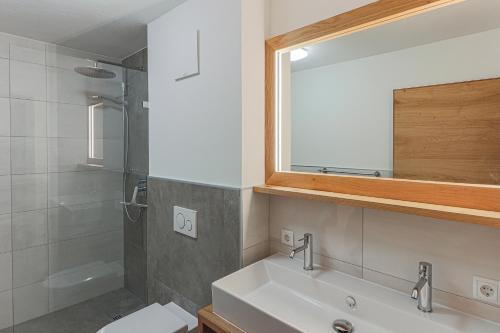 ein Badezimmer mit einem Waschbecken, einem WC und einem Spiegel in der Unterkunft Residenz Brixental Top 7 in Brixen im Thale