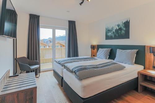 ein Schlafzimmer mit einem großen Bett und einem Fenster in der Unterkunft Residenz Brixental Top 7 in Brixen im Thale