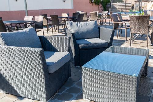 a group of wicker chairs and tables on a patio at Hotel Mettlacher Hof in Mettlach