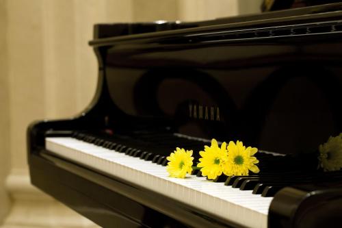 two yellow flowers sitting on top of a piano at Eldora Hotel in Hue