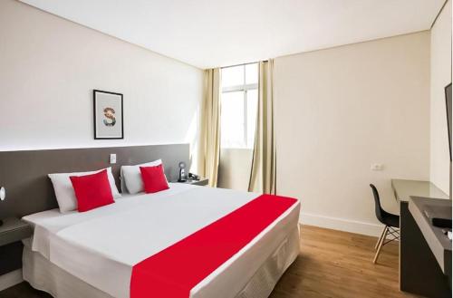 a bedroom with a large bed with red pillows at Hotel InterAmericana in Americana