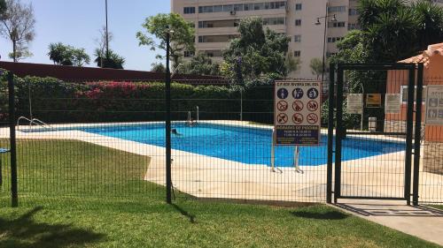 una valla con un cartel junto a una piscina en apartamento Torreblanca del sol Beach en Fuengirola