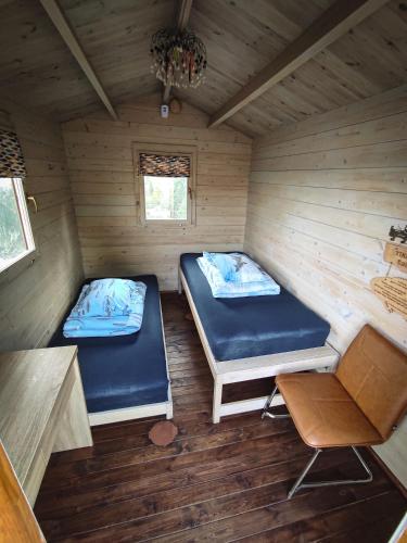 a room with two beds in a wooden cabin at Kupiškėnų Starkėnas in Palėvenėlė