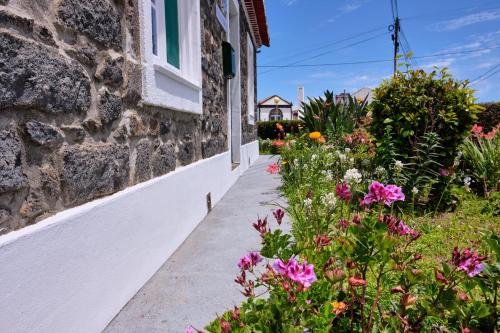 a sidewalk next to a building with flowers at Casa D'Eira in Nordeste