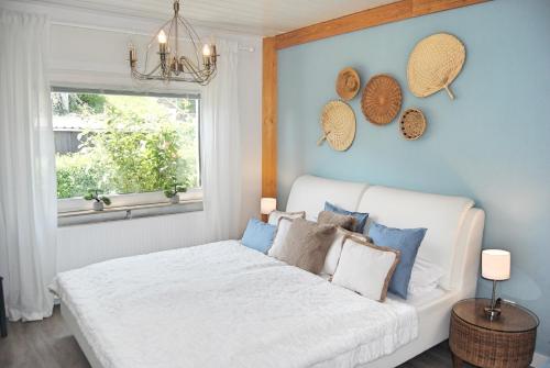 a bedroom with a white bed and a window at Stilvolles Eifelhaus am Nürburgring mit eigenem Garten in Boos