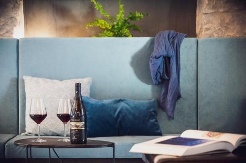 a bottle of wine and two glasses on a couch at VistaLago Torbole in Nago-Torbole