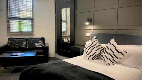 - une chambre avec un grand lit et un canapé dans l'établissement Siberia Bar & Hotel, à Aberdeen
